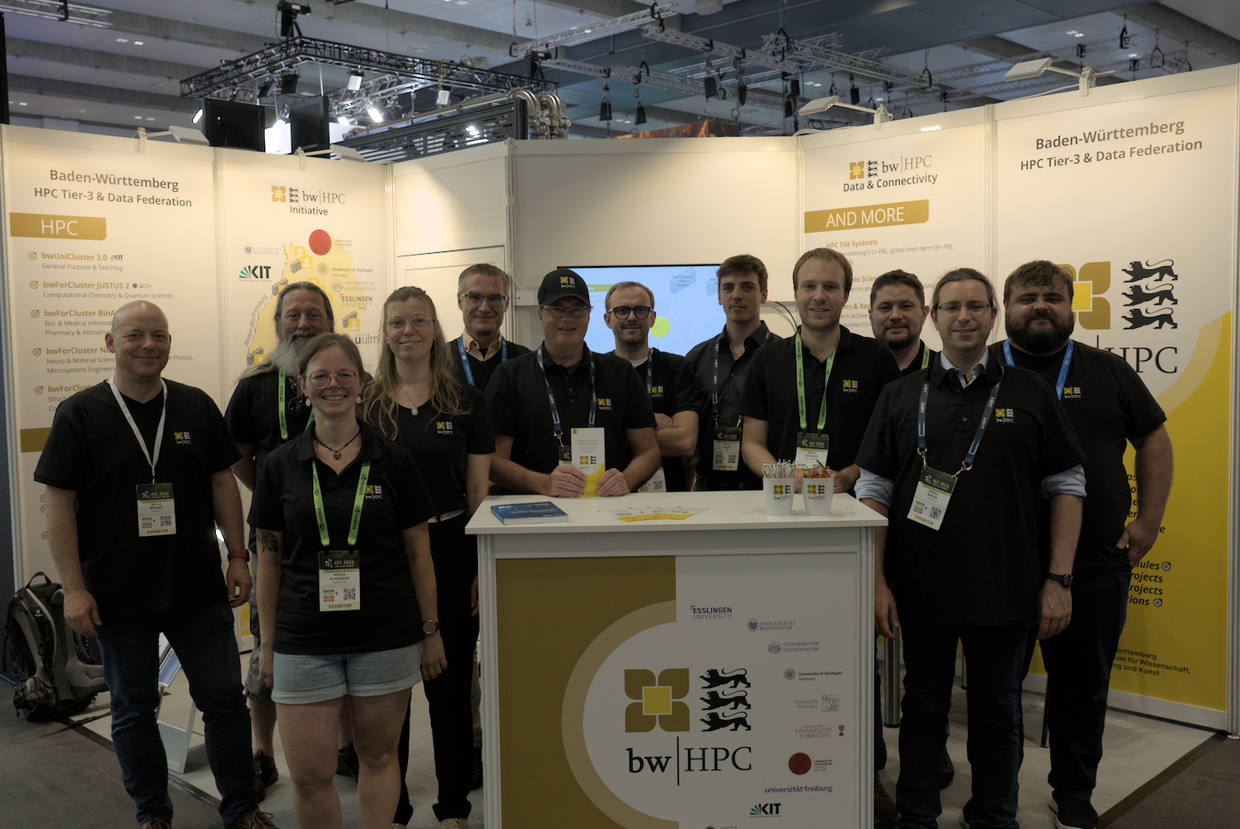 Group of professionals posing at a bwHPC exhibition booth.