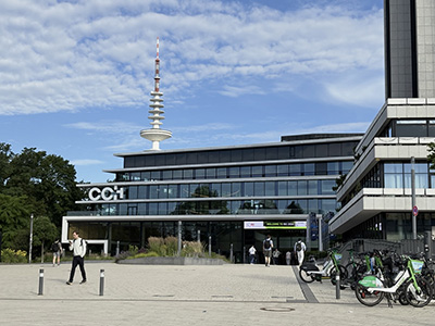 Modern building with "CCK" signage and a tall communication tower under a blue sky.
